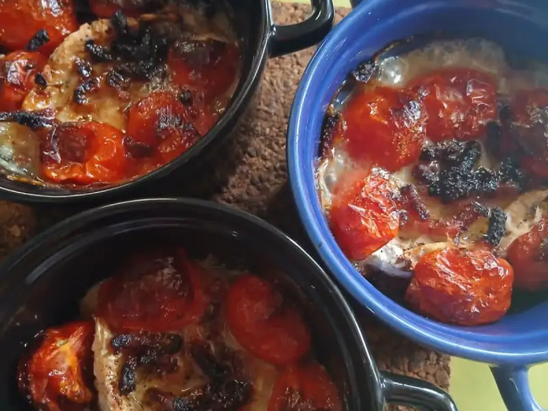 Tre cocotte di pollo con pomodorini arrostiti e mozzarella gratinata appena sfornate