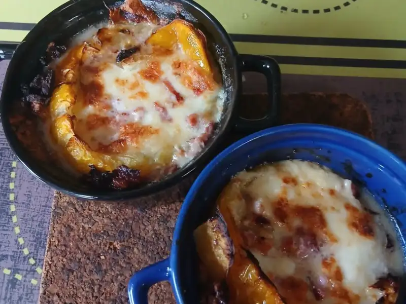 Due cocotte di pomodoro giallo, mozzarella e pancetta gratinati